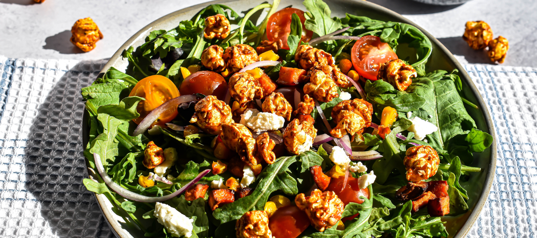 an arugula salad topped with BBQ popcorn