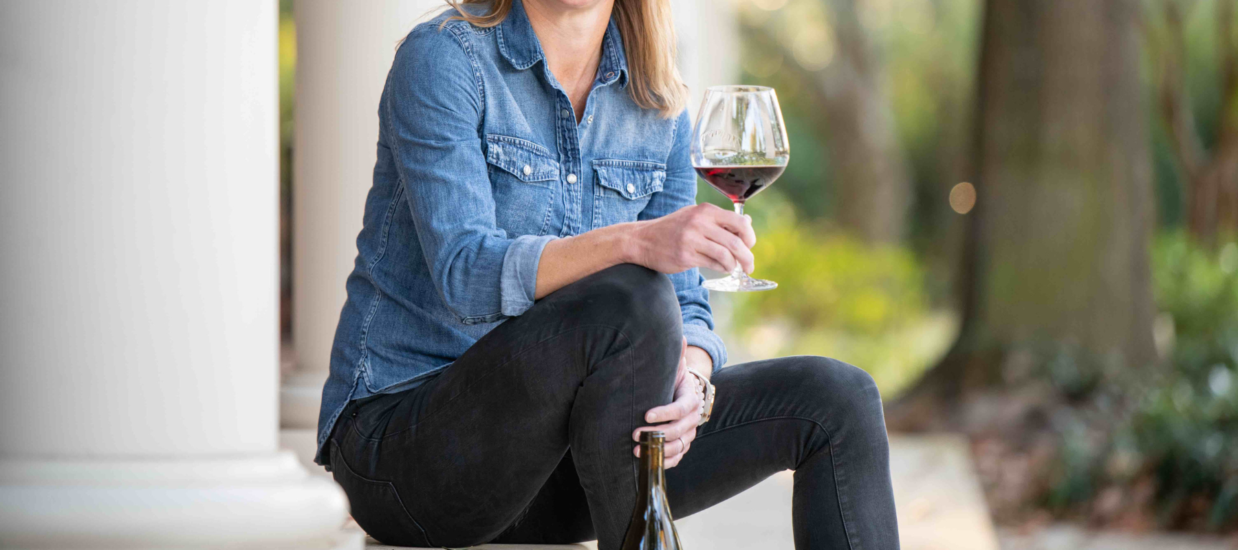 A woman holds a glass of red wine