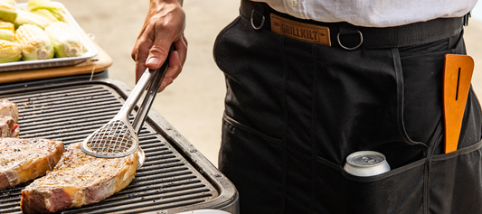 Father's Day Dinner in process: grilling with tongs and an apron