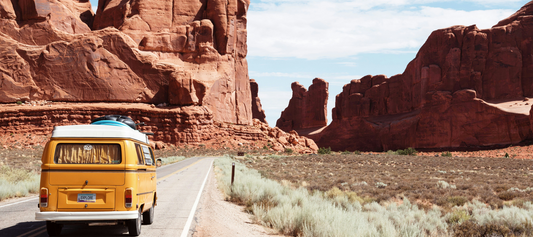 a van winding down a desert road