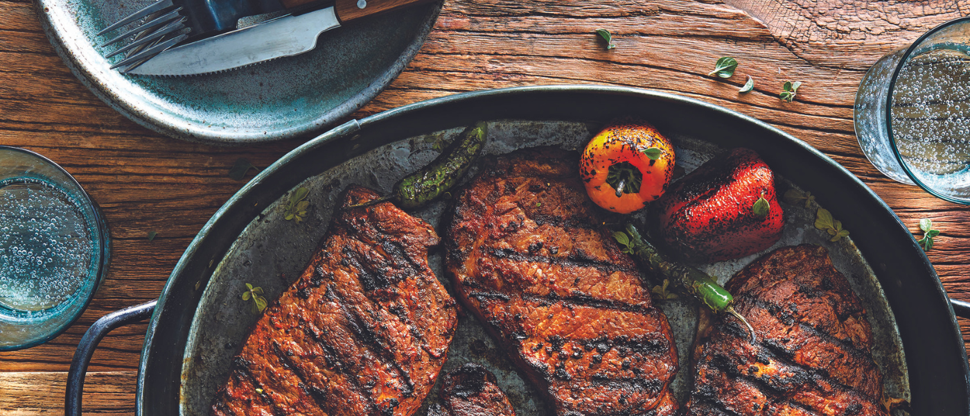 Steaks and grilled peppers prepared with sauces and seasonings from the Labor Day Gift Guide