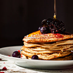 Pancake stack topped with blueberries and maple syrup for Southern baking