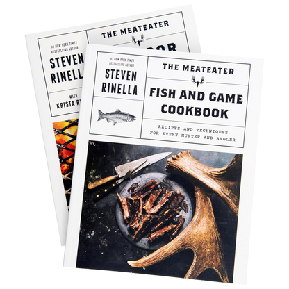 Two copies of The Meateater Fish and Game Cookbook and Outdoor Cooking Cookbook by Steven Rinella, with the front copy showing a white cover, a fish illustration, and a photo of cooked game meat on a plate with antlers.