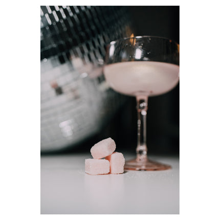 Storied Goods Celebration Sugar Cubes with a drink in the background 